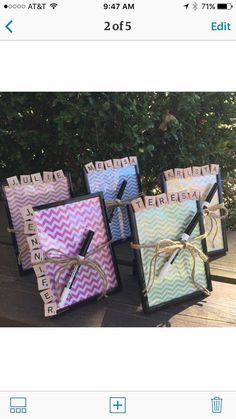 three small boxes with writing on them are sitting on a wooden table next to some trees