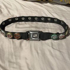 a belt with several different badges on it sitting on top of a white bed sheet