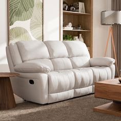 a living room with a white couch and coffee table in front of a book shelf