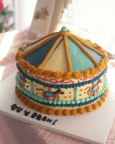 a decorated carousel cake sitting on top of a table