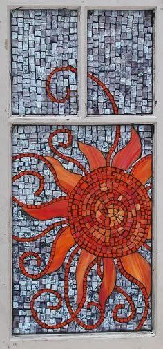 a stained glass window with an orange sun on it