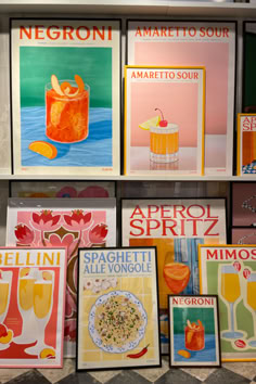 several posters are on display in a store window with oranges and lemonade drinks