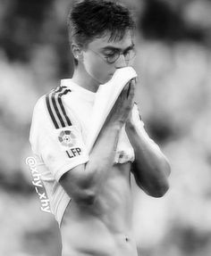 a shirtless soccer player wiping his face with a towel