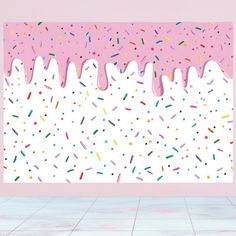 a pink wall with sprinkles on it in front of a tiled floor