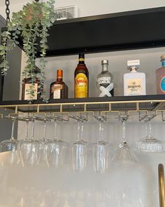 wine glasses and liquor bottles are sitting on a shelf