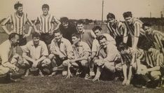 a group of men standing next to each other on a field