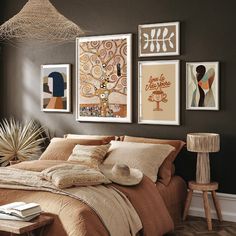 a bedroom with brown walls and pictures on the wall above the bed in front of it