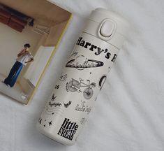 a harry potter water bottle next to a book on a white sheet with a boy in the background