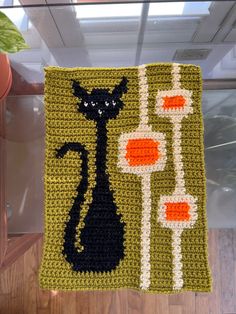 a crocheted square with a black cat on it