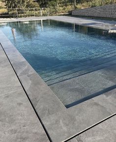 an empty swimming pool surrounded by stone walls