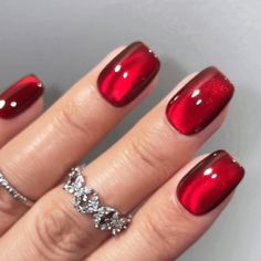 a woman's hand with red nail polish and diamond ring on her left finger