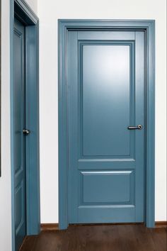 an empty room with blue doors and wooden floors