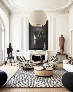 a living room filled with furniture and a large painting on the wall above it's fireplace