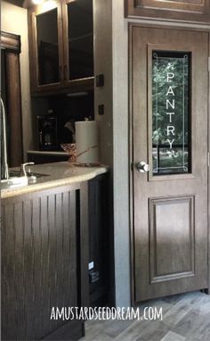 the inside of a home with wood paneling and stainless steel door handles, windows, and cabinets