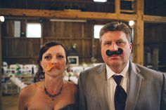 a man and woman with fake moustaches on their faces