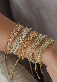 a woman's arm with several bracelets on it