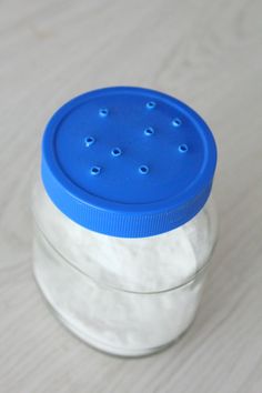 a glass jar with blue lid sitting on a table