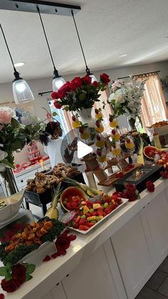 a buffet with flowers and fruits on it