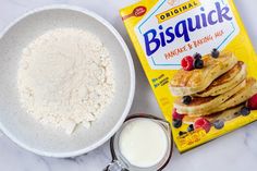 a bowl of pancakes next to a carton of bisquick