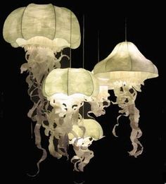 some very pretty lights that are hanging in the dark room with jellyfish on them