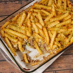 a casserole dish filled with french fries covered in cheese and meat toppings