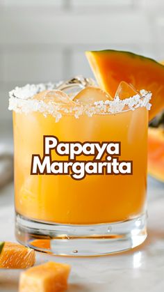 a close up of a drink on a table with fruit in the background and text papaya margarita