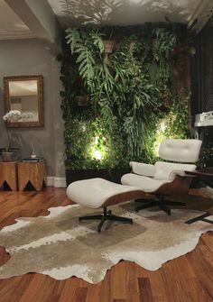 an image of a living room with plants on the wall and white chairs in front of it