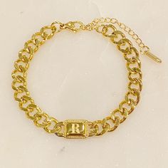 This Uptown Cuban Chain Initial Bracelet is a stylish and edgy addition to any look. The center tag features a nicely engraved initial and the combination of the unisex cuban chain make for a distinctive piece. Great for styling alone or to create layered looks. Dimensions: approximately 7 inch with a 2" extender 18k Gold plated Stainless Steel, Tarnish and water resistant finish Lead and Nickel Free Made in China Gold-tone Cuban Link Bracelet As Gift, Luxury Tarnish-resistant Gold Plated Cuban Link Bracelet, Silver-toned 14k Gold Cuban Link Bracelet As Gift, Classic Cuban Link Gold Bracelet, Tarnish Resistant, Gold-tone Tarnish Resistant Cuban Link Bracelet, Bracelet Initial, Hair Setting, Cuban Chain, Initial Bracelet