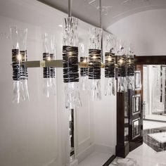 a chandelier hanging from the ceiling in a room with white walls and marble flooring