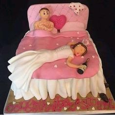 there is a cake that looks like a bed with a woman laying on it and a man holding a heart