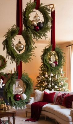 a living room decorated for christmas with wreaths hanging from the ceiling