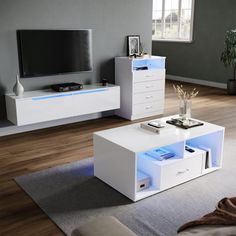 a living room filled with furniture and a flat screen tv on top of a white table