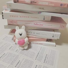 a stack of books with a stuffed animal sitting on top of them next to each other