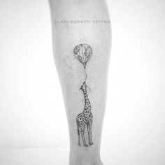 a giraffe with a balloon tattoo on its leg