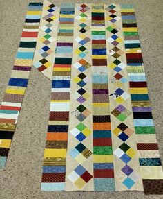 a multicolored patchwork quilt laid out on the floor next to each other