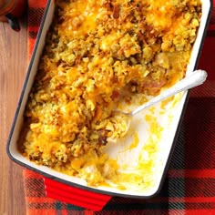 a casserole dish with meat and cheese in it on a plaid table cloth