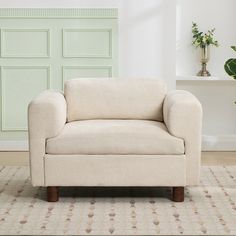 a living room with a chair and potted plant