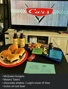 two hamburgers and three bottles of beer on a table in front of a tv