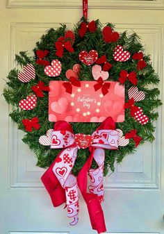 a valentine's day wreath hanging on the front door with lights and decorations around it