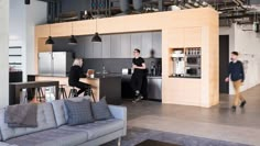 two men are standing in the middle of a kitchen