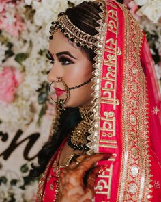 a woman wearing a red and gold bridal outfit