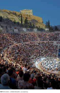 a large crowd is sitting in front of the acrobatic arena at the ancient greek theatre