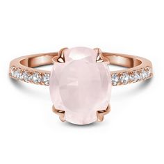 a rose quartz ring with diamonds on the band and an oval stone in the center