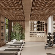 a gym with rows of exercise mats and wall mounted dumbbells in the middle