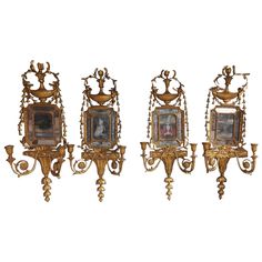 three ornate wall sconces with paintings on them