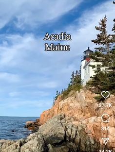 the lighthouse is located on top of the rocky cliff by the water and has words written below it that read acadia maine