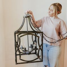 a woman holding a lantern with candles in it