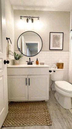 a bathroom with a toilet, sink, mirror and shower curtain in it's corner