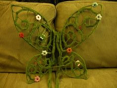 a crocheted butterfly sitting on top of a couch