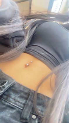 a woman with grey hair and piercings on her stomach